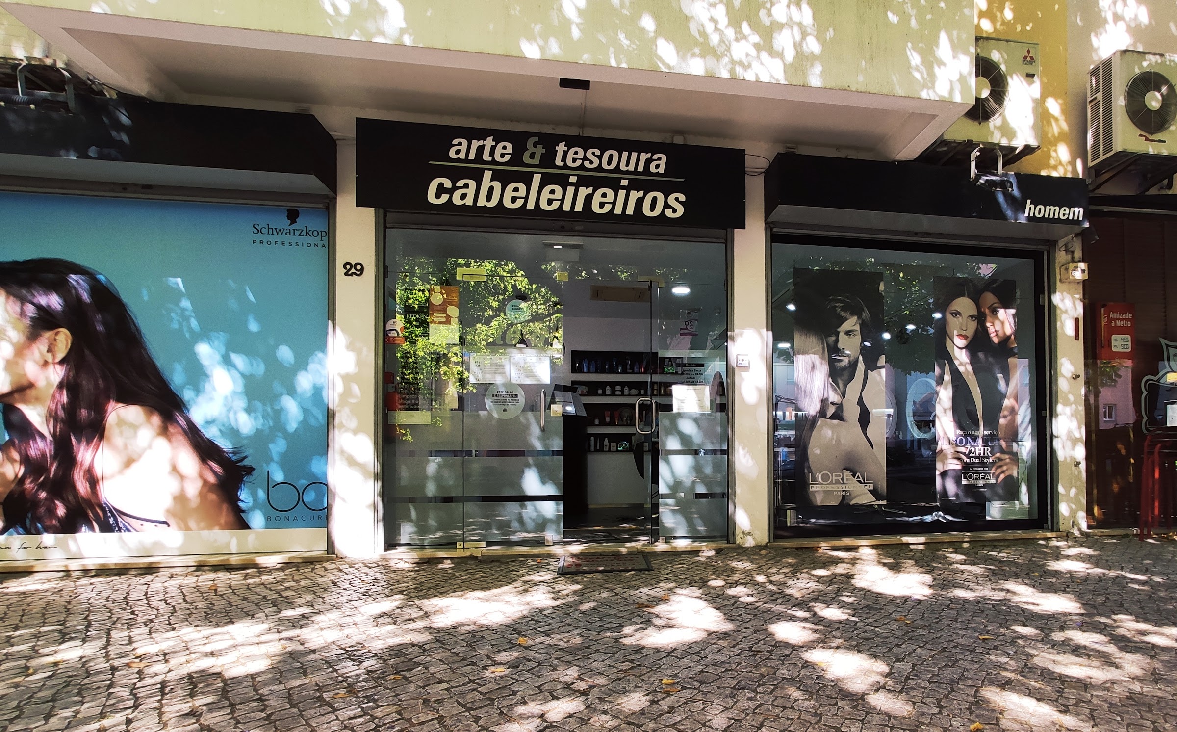 Montra do arte & tesoura cabeleireiros na Rua Professor João Barreira, com o letreiro preto e a secção de homem à direita